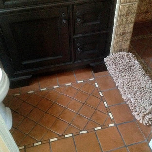 Modelo de habitación de invitados de tamaño medio con paredes beige y suelo de baldosas de terracota