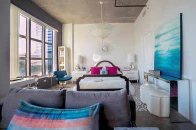 Example of a mid-sized transitional loft-style concrete floor and brown floor bedroom design in Miami with white walls and no fireplace