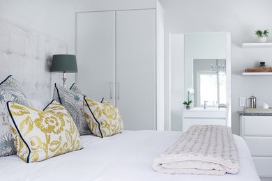Ispirazione per una camera degli ospiti design di medie dimensioni con pareti bianche e pavimento in laminato