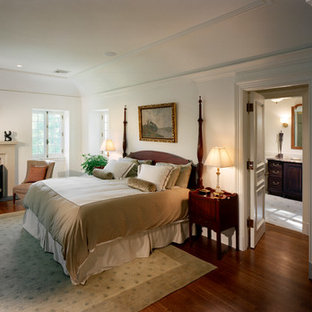 Example of a french country dark wood floor bedroom design in New York with white walls and a standard fireplace