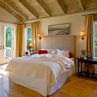 Immagine di una camera da letto con pareti beige, pavimento in legno massello medio e pavimento giallo