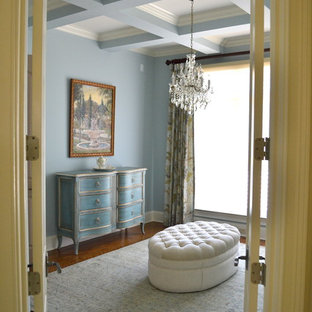 Imagen de dormitorio principal, tradicional, de tamaño medio, sin chimenea, con paredes azules, suelo de madera clara y suelo marrón