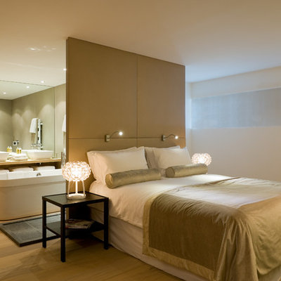 Example of a large trendy master light wood floor bedroom design in Other with white walls