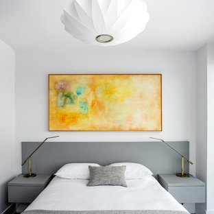 Foto de dormitorio principal, minimalista, pequeño, con paredes blancas, suelo laminado y suelo marrón
