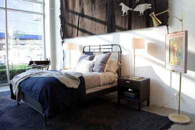 Imagen de dormitorio bohemio con paredes blancas y suelo de cemento