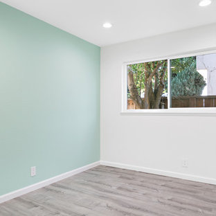 Ejemplo de habitación de invitados clásica renovada, de tamaño medio, sin chimenea, con paredes azules, suelo laminado y suelo marrón