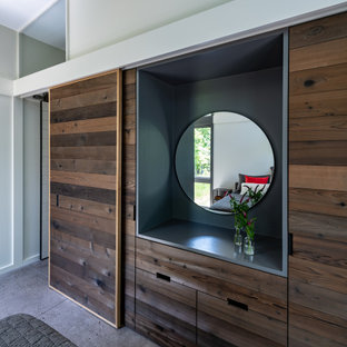Modelo de dormitorio principal, moderno, pequeño, con suelo de cemento, marco de chimenea de hormigón y suelo gris