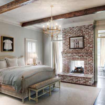 Inspiration for a mid-sized timeless master medium tone wood floor bedroom remodel in Other with gray walls, a brick fireplace and a two-sided fireplace