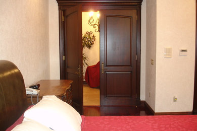 Diseño de dormitorio principal clásico de tamaño medio sin chimenea con paredes beige y suelo de madera oscura