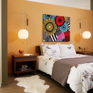 Ejemplo de dormitorio industrial con parades naranjas y suelo de madera en tonos medios