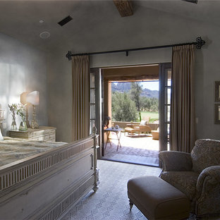 Idée de décoration pour une chambre champêtre de taille moyenne avec un mur gris, une cheminée standard, un manteau de cheminée en béton et un sol beige.