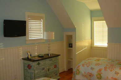 Inspiration for a mid-sized guest medium tone wood floor bedroom remodel in Raleigh with blue walls and no fireplace