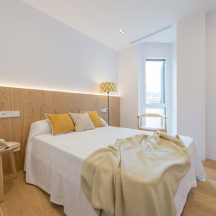 Imagen de dormitorio nórdico, de tamaño medio, sin chimenea, con paredes blancas y suelo de madera clara