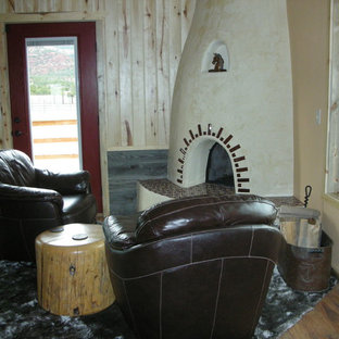 Cette photo montre une grand chambre parentale sud-ouest américain avec un mur beige, un sol en bois clair, une cheminée d'angle et un manteau de cheminée en plâtre.