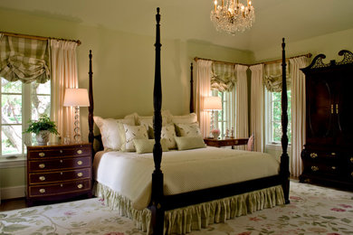 Mid-sized elegant guest medium tone wood floor and brown floor bedroom photo in Austin with green walls