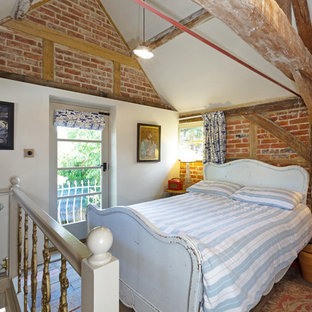 Modelo de dormitorio tipo loft, de estilo de casa de campo, con paredes rojas