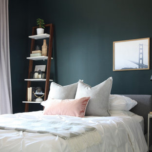 Modelo de dormitorio principal, ecléctico, pequeño, con paredes verdes, suelo laminado y suelo marrón