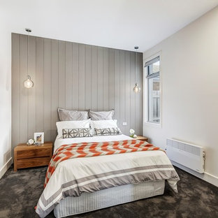 Scandinavian master bedroom in Melbourne with white walls, carpet and grey floor.