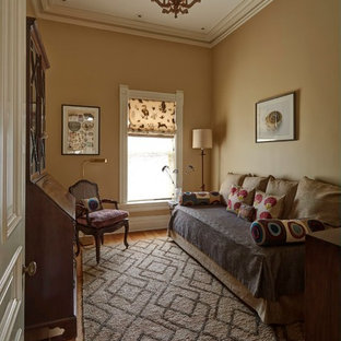 Kleines Eklektisches Gästezimmer mit gelber Wandfarbe und braunem Holzboden in Chicago