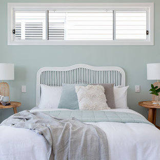 This is an example of a beach style bedroom in Brisbane with white walls, carpet and grey floor.