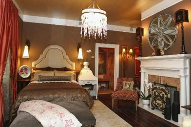 ハンティントンにある中くらいなトラディショナルスタイルのおしゃれな客用寝室 (茶色い壁、濃色無垢フローリング、標準型暖炉、石材の暖炉まわり) のインテリア