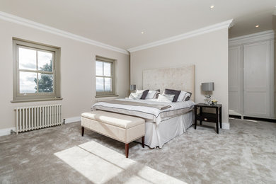 This is an example of a large classic master bedroom in Surrey with grey walls, carpet and grey floors.