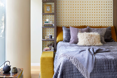 Example of a small trendy medium tone wood floor and brown floor bedroom design in New York with beige walls