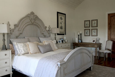 Imagen de dormitorio principal clásico de tamaño medio sin chimenea con paredes blancas, suelo de madera oscura y suelo marrón