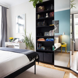 Modelo de dormitorio principal, escandinavo, pequeño, con paredes multicolor y suelo de madera en tonos medios