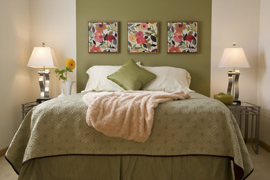 Modelo de dormitorio principal clásico de tamaño medio con paredes verdes y moqueta