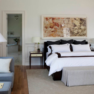 Example of a classic master medium tone wood floor bedroom design in New York with white walls