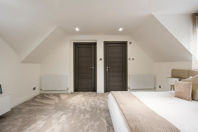 Großes Modernes Gästezimmer mit weißer Wandfarbe, Teppichboden und beigem Boden in Manchester