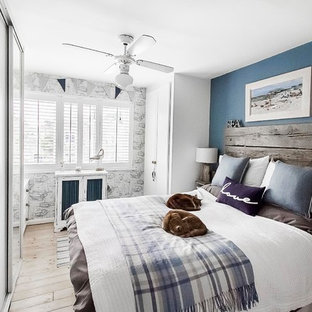 Inspiration for a medium sized beach style master bedroom in London with blue walls, light hardwood flooring, no fireplace and brown floors.