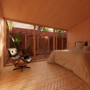 Imagen de habitación de invitados moderna, pequeña, sin chimenea, con parades naranjas, suelo de ladrillo y suelo beige