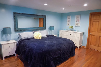 デトロイトにある中くらいなビーチスタイルのおしゃれな客用寝室 (青い壁、淡色無垢フローリング、茶色い床) のレイアウト