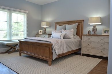 Modelo de habitación de invitados clásica renovada de tamaño medio sin chimenea con paredes azules, suelo marrón y suelo de madera en tonos medios