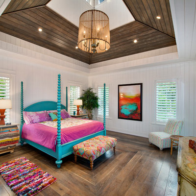 Example of a large island style master medium tone wood floor bedroom design in Miami with white walls