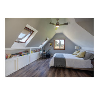Modelo de habitación de invitados actual, de tamaño medio, con paredes grises, suelo laminado y suelo marrón