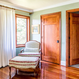 Imagen de habitación de invitados clásica, de tamaño medio, sin chimenea, con paredes verdes, suelo de madera en tonos medios y suelo rojo