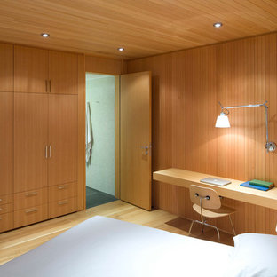 Diseño de dormitorio principal, escandinavo, grande, sin chimenea, con suelo de madera clara, paredes marrones y suelo marrón
