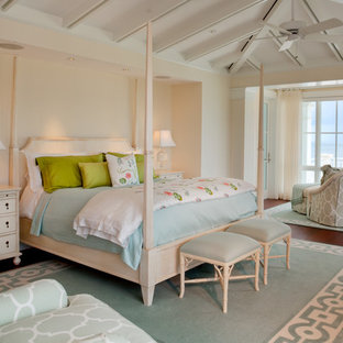 Example of an island style dark wood floor bedroom design in Miami with beige walls