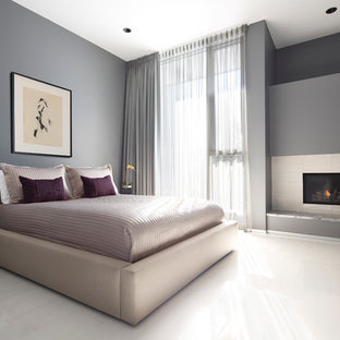 Immagine di una camera da letto contemporanea con pareti grigie, pavimento in legno verniciato, camino lineare Ribbon e pavimento bianco