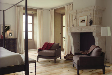 ボイシにある中くらいなコンテンポラリースタイルのおしゃれな主寝室 (ベージュの壁、淡色無垢フローリング、標準型暖炉、石材の暖炉まわり)