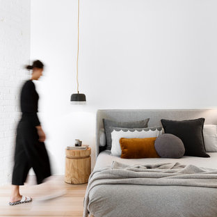 Inspiration for a scandinavian bedroom in Melbourne with white walls, light hardwood floors and no fireplace.
