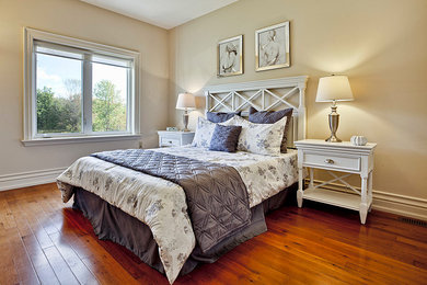 Elegant guest light wood floor bedroom photo in Toronto with beige walls and no fireplace