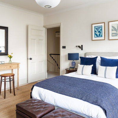 Example of a transitional bedroom design in London with white walls