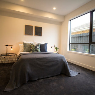 Ejemplo de habitación de invitados actual, grande, con paredes blancas, moqueta y suelo azul