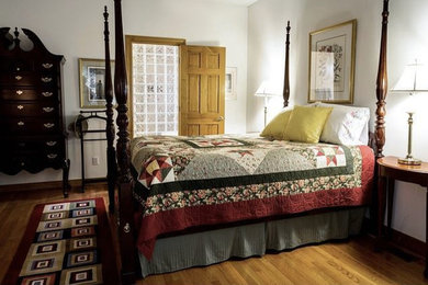 フェニックスにある中くらいなトラディショナルスタイルのおしゃれな主寝室 (白い壁、無垢フローリング、暖炉なし、茶色い床)