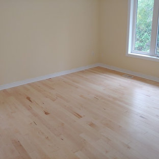 Foto di una camera degli ospiti design di medie dimensioni con pareti beige, parquet chiaro e pavimento giallo