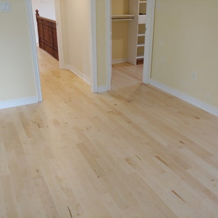 Esempio di una camera matrimoniale design di medie dimensioni con pareti beige, parquet chiaro e pavimento giallo